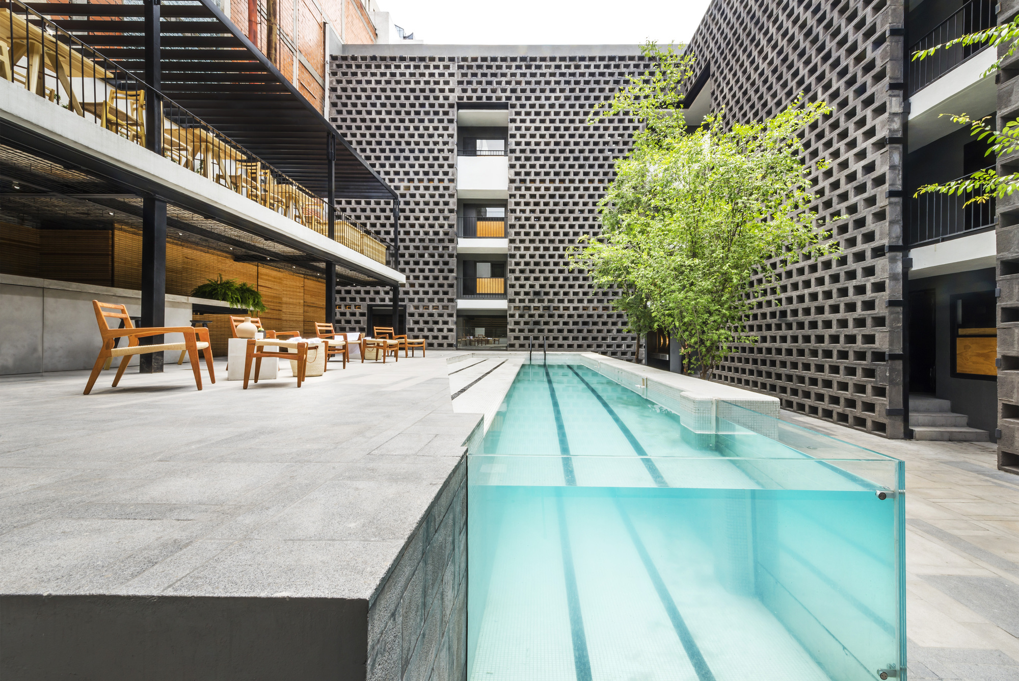 Courtyard with a swimming pool behind a glass wall in a city hotel