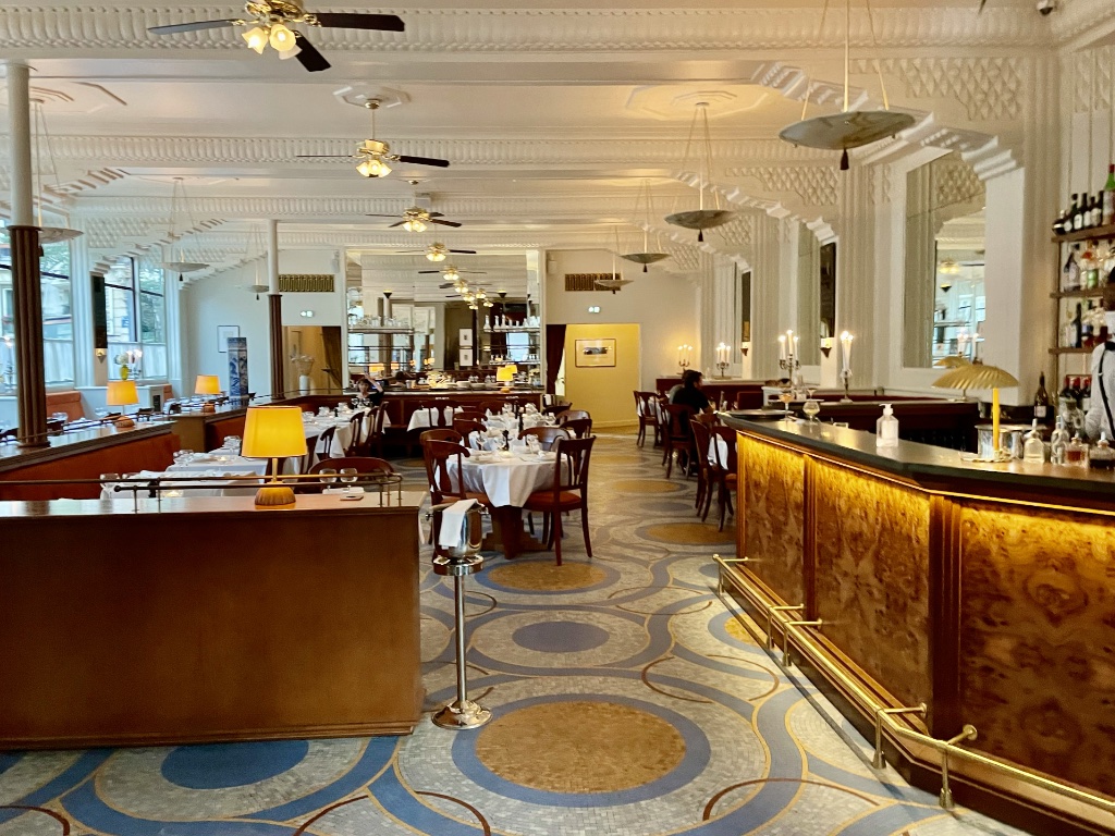 Lobby with terrazzo floor, brass fittings and curved forms in a Paris hotel
