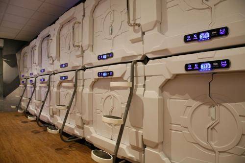 Sleeping cabin with a bed and a small luggage space inside an airport terminal