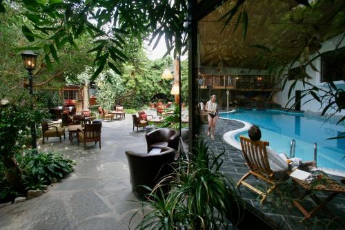 Outdoor pool beside a timber mountain hotel surrounded by forest